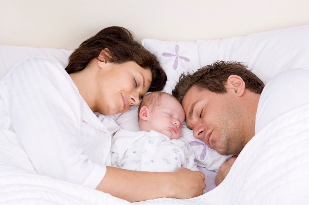 New parents sleeping with their new born baby