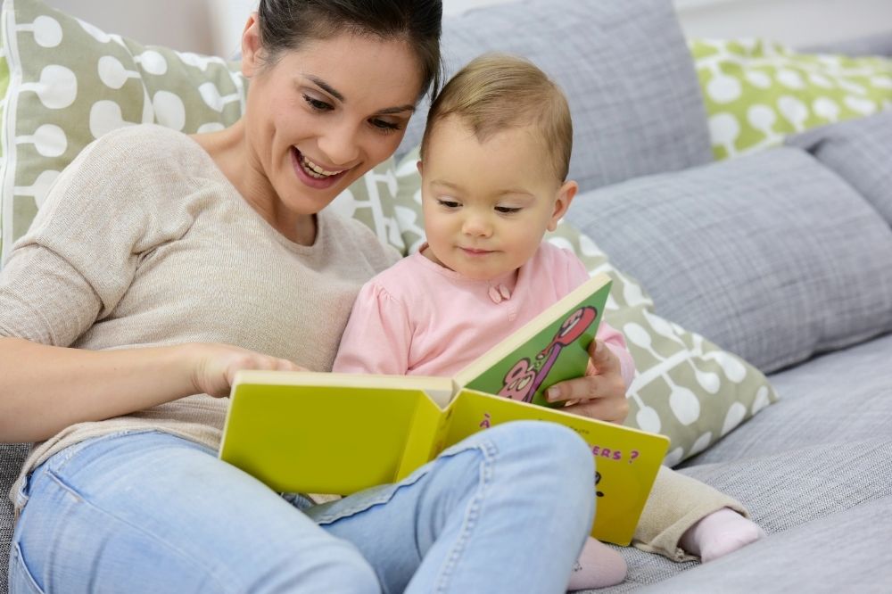 Mom reading book to her 15 month old baby